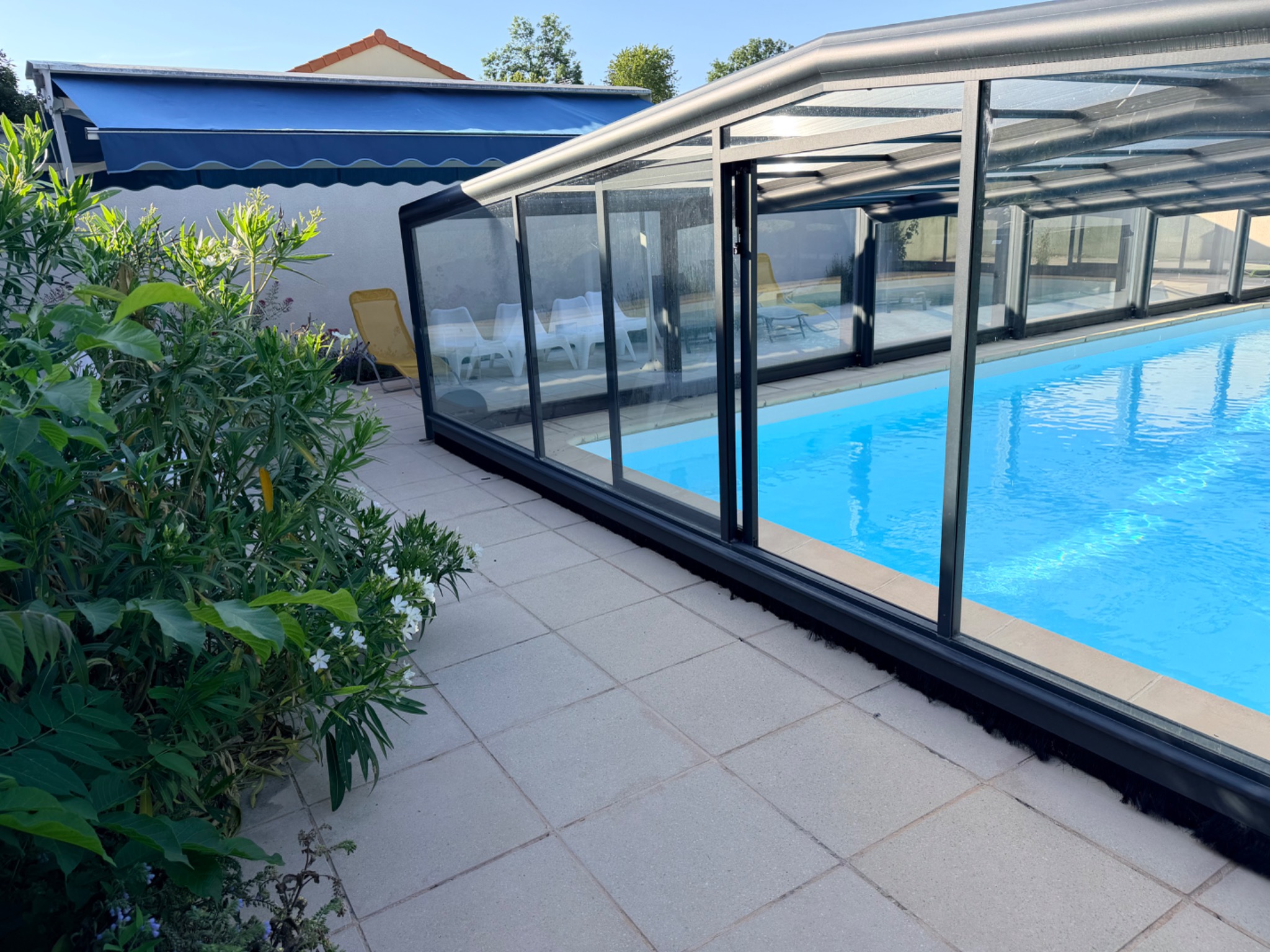 Vue extérieure de la piscine et de son abri ouvert